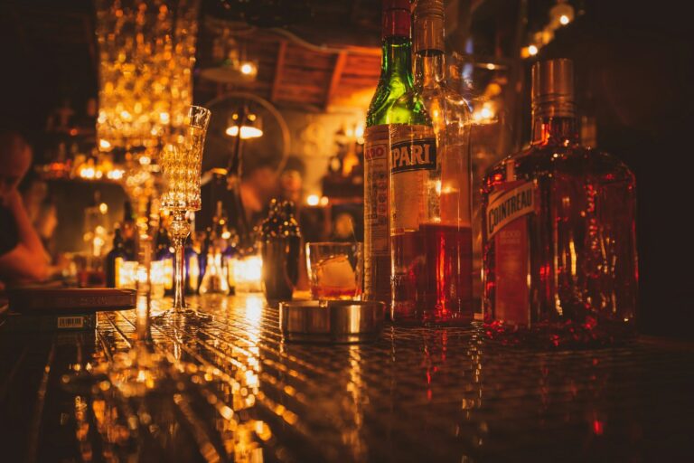 Estante iluminado con botellas de licor en un bar